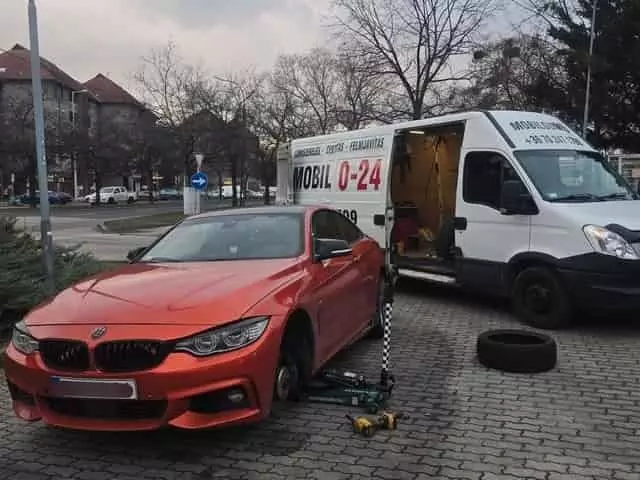 Téli-nyári szezonváltás Budapesten Otthoni kerékcsere Budapesten, piros BMW autón kocsifelhajtón